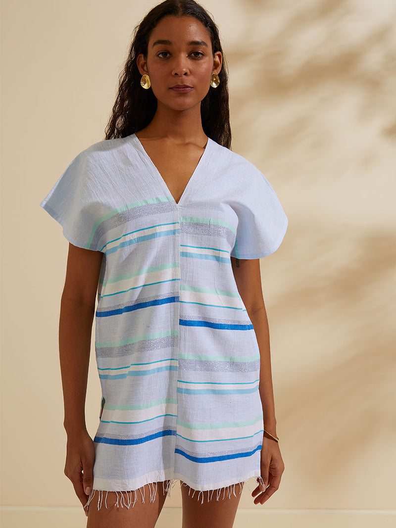 Woman standing wearing the Ruki Split Tunic featuring a mutli tonal stripe pattern in five shades of blue with silver and white accents.