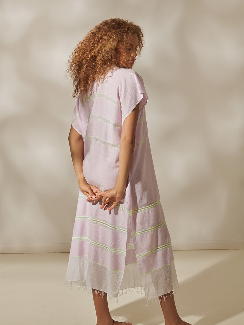 Back of a Woman Standing Wearing Ruti Dalila V Neck Caftan Featuring lilac orchid color complemented by hints of citron neon.