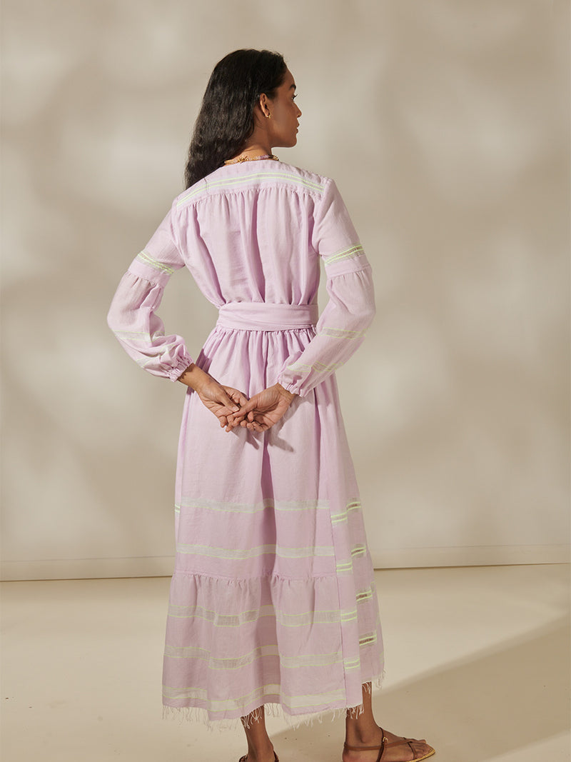 Back view of a Woman Standing Wearing Ruti Elisabet Belted Dress Featuring lilac orchid color complemented by hints of citron neon.