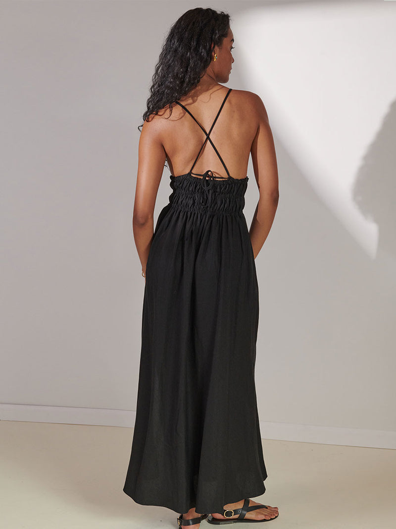 Back View of a Woman Standing Wearing lemlem Gete Triangle Dress in Black Color