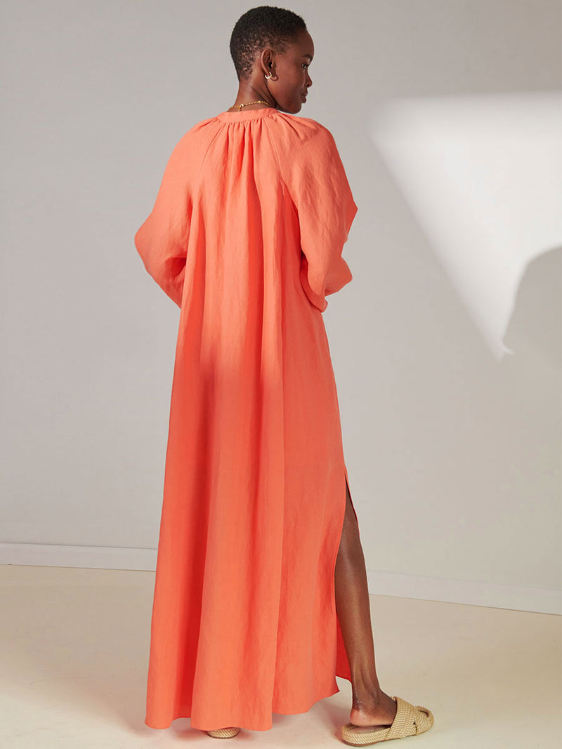 Back View of Woman Standing Wearing lemlem Makeda Button Up Dress in Coral Color