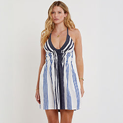 Woman standning wearing lemlem handwoven KAYLA Dress featuring navy striped pattern