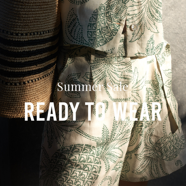 Close up on a woman wearing lemlem linen top and matching shorts with a raffia bag with sale message overlay.