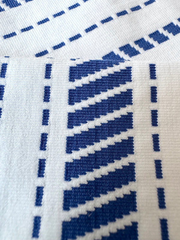 Close up on lemlem swim fabric featuring custom jacquard in crisp white and bright blue, inspired by our handwoven pattern.