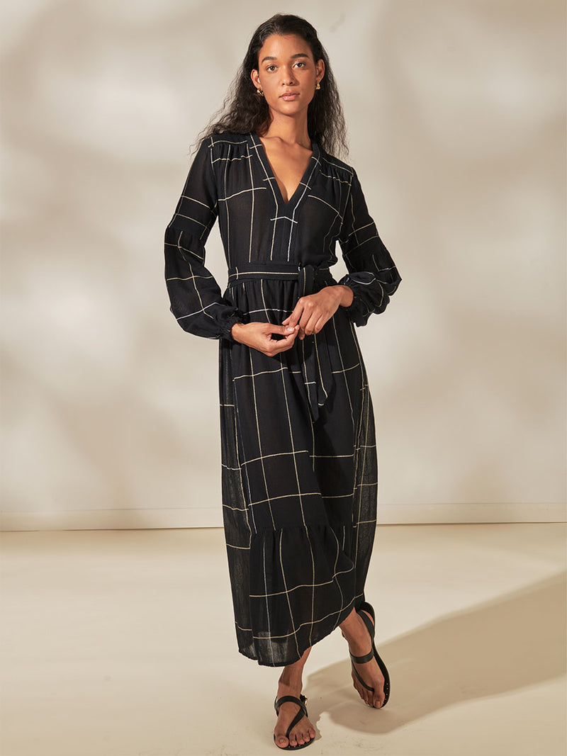 Woman Standing Wearing Elsabet Belted Maxi Dress featuring Big White Plaid Patten on Black Cotton Background