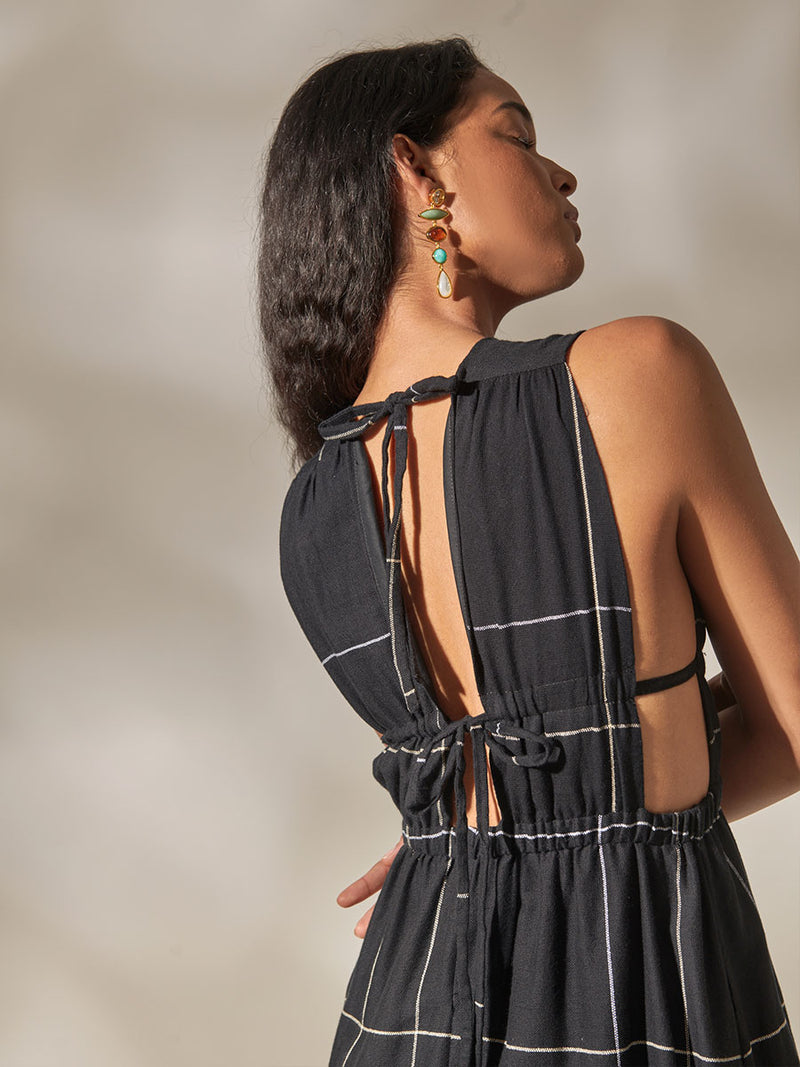 Back View of a Woman Standing Wearing Lelisa V Neck Maxi Dress featuring Big White Plaid Patten on Black Cotton Background