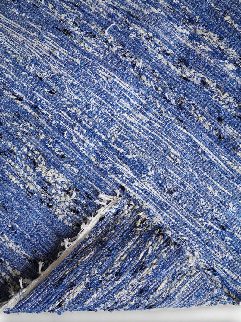 Close up shot of a Folded Blue & Black Rug Featuring Black, White and Blue color accents