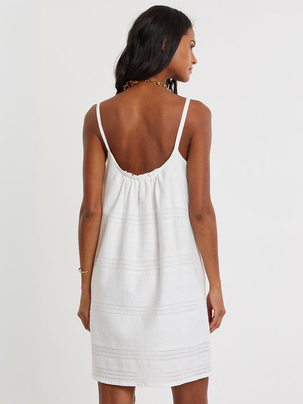 Woman standing wearing lemlem ZINA handwoven dress in white color