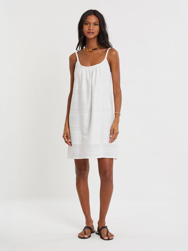 Woman standing wearing lemlem ZINA handwoven dress in white color
