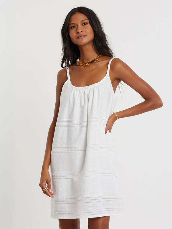 Woman standing wearing lemlem ZINA handwoven dress in white color