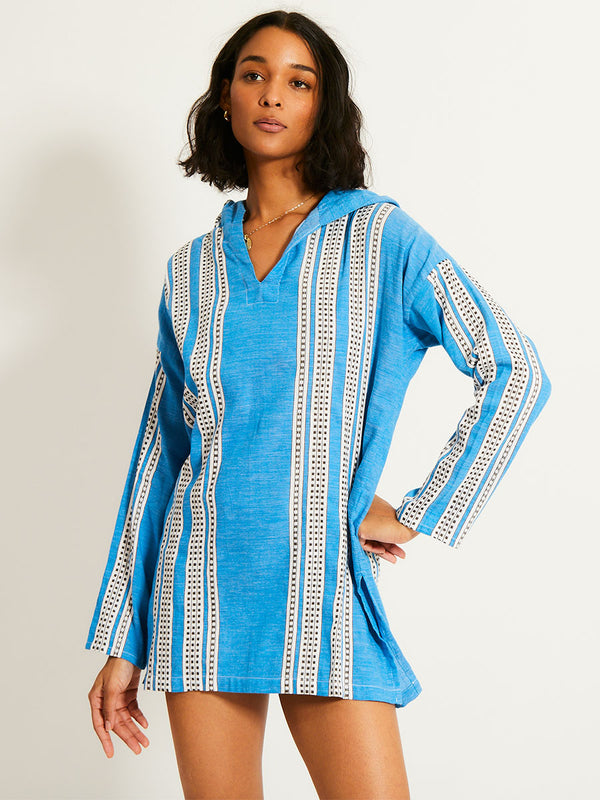 Woman Standing Wearing lemlem HENOK Hoodie featuring classic Amira pattern with small geometric bands that float on a rich teal blue ground