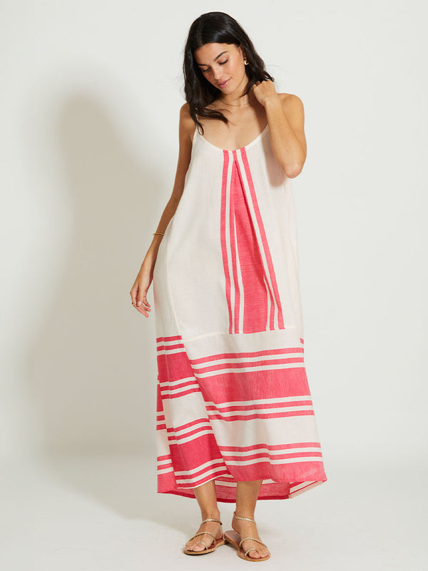 Woman Standing Wearing lemlem NIA | Slip Dress featuring bold two-tone stripe pattern in watermelon pink and soft rosy cream