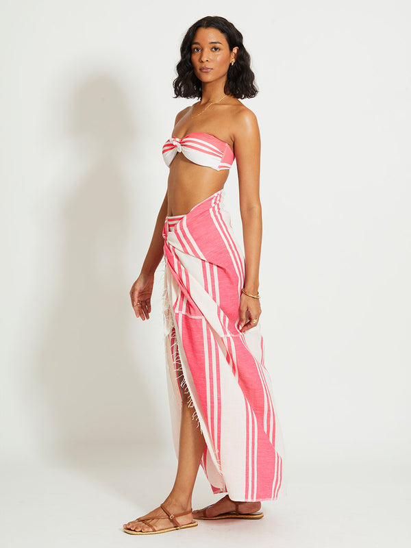 Woman Standing Wearing lemlem TALAKI | Sarong featuring bold two-tone stripe pattern in watermelon pink and soft rosy cream