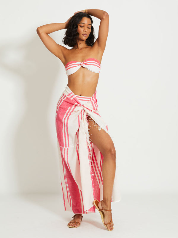 Woman Standing Wearing lemlem TALAKI | Sarong featuring bold two-tone stripe pattern in watermelon pink and soft rosy cream