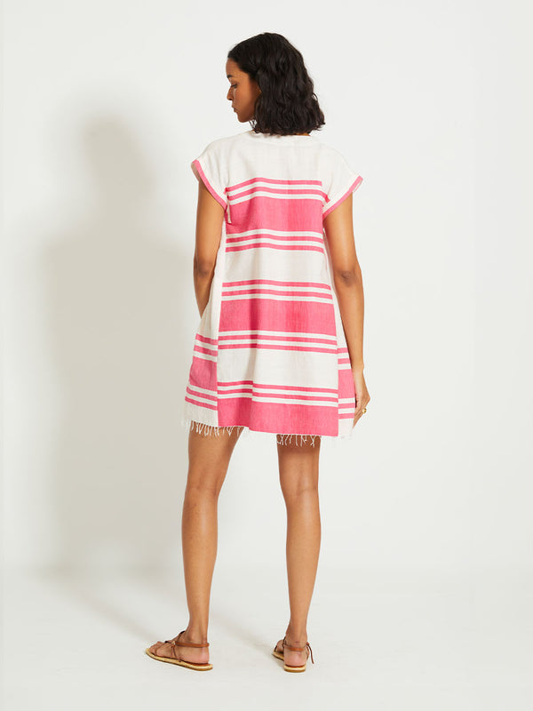Back of a Woman Standing Wearing lemlem ELINA | Caftan featuring bold two-tone stripe pattern in watermelon pink and soft rosy cream