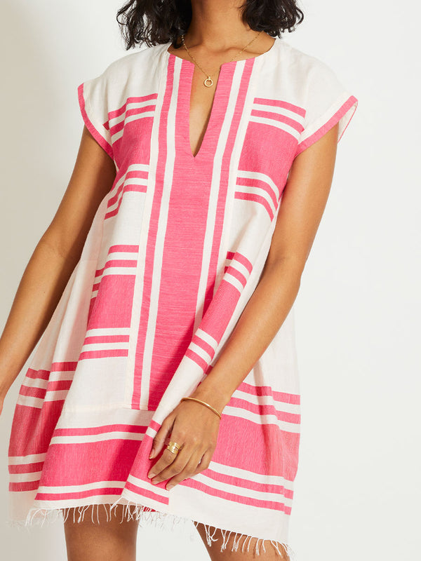 Close up on a Woman Standing Wearing lemlem ELINA | Caftan featuring bold two-tone stripe pattern in watermelon pink and soft rosy cream