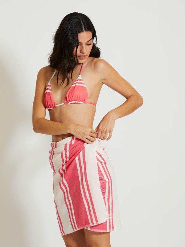 Woman Standing Wearing lemlem LEMA | Sarong featuring bold two-tone stripe pattern in watermelon pink and soft rosy cream