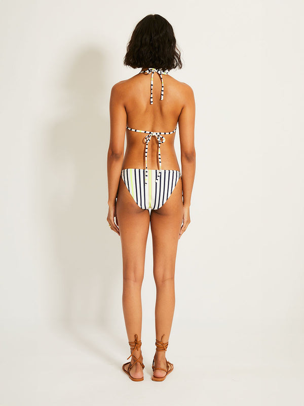 Back of a Woman Standing Wearing lemlem MALIA Triangle Top featuring an ivory ground with navy stripes, accented by khaki and citron hues
