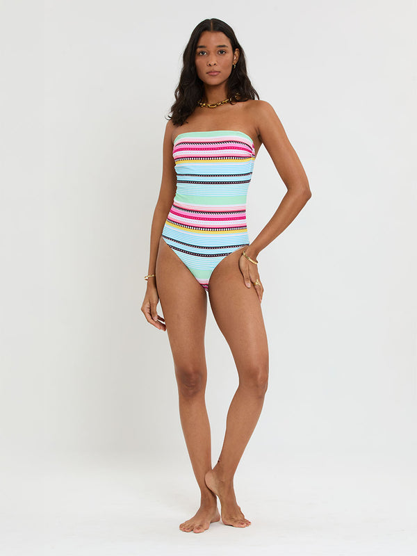 Woman Standing Wearing lemlem DINHA One Piece featuring intricate stripes and a tibeb pattern in vivid combinations of green, aqua, turquoise, pink, and soft peach-tangerine tones.
