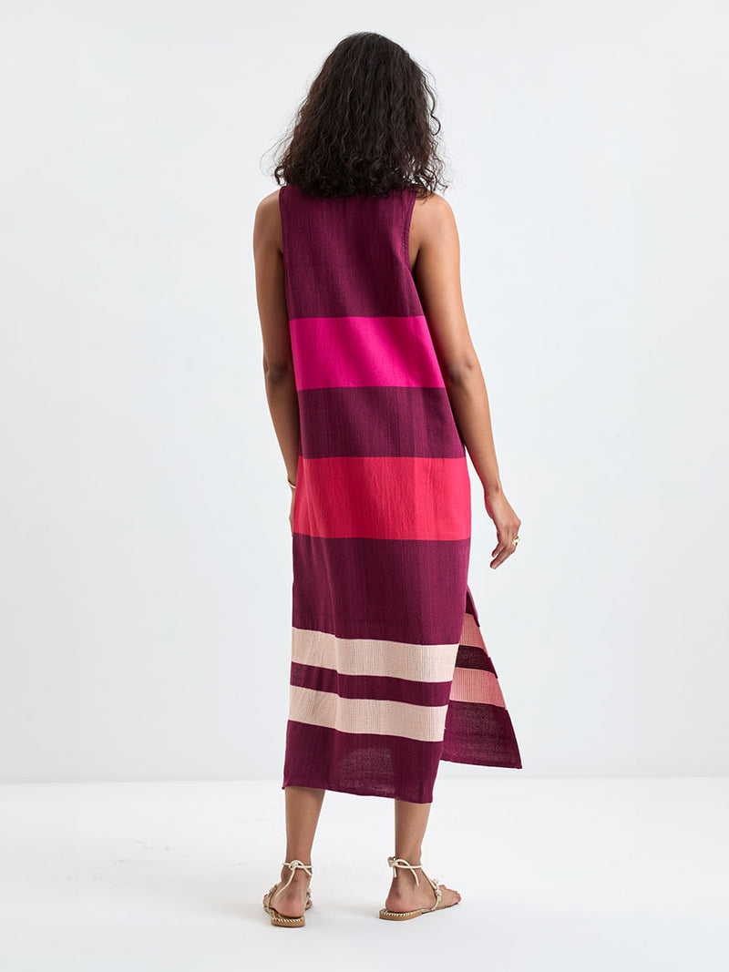 Back of a Woman standing wearing lemlem LILIAN Tank Dress featuring a striking color-block combination of vivid magenta, scarlet, and burgundy colors.