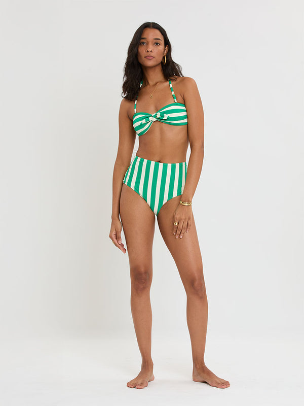 Woman Standing Wearing lemelm AVA Bandeau Top and ELSI High Waist Bottom featuring classic cabana stripe in classic green, accented by soft ivory.