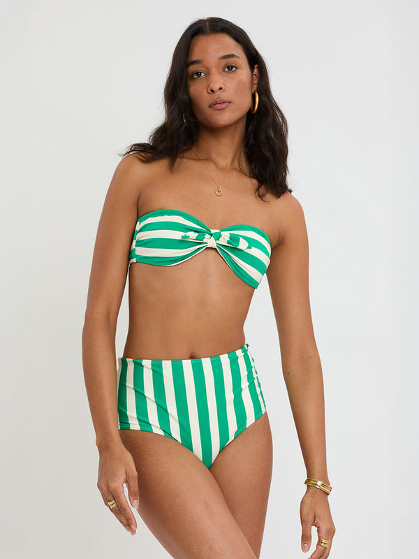 Woman Standing Wearing lemelm AVA Bandeau Top and ELSI High Waist Bottom featuring classic cabana stripe in classic green, accented by soft ivory.