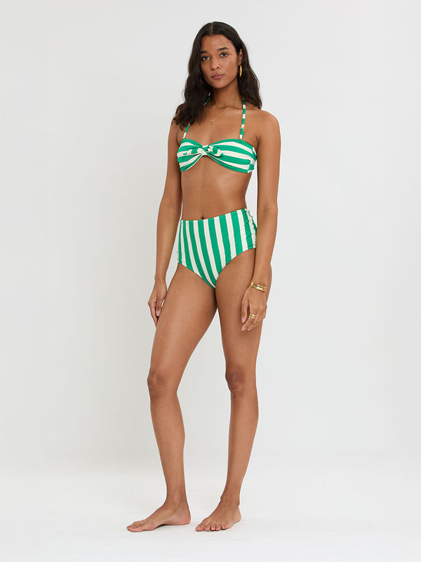 Woman Standing Wearing lemelm AVA Bandeau Top and ELSI High Waist Bottom featuring classic cabana stripe in classic green, accented by soft ivory.