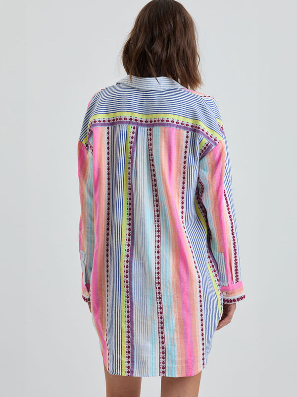 Back of a Woman Standing Wearing lemlem MARIAM | Shirt Dress featuring  intricate stripes in sun-washed hues and a Tibeb-inspired pattern in rich dark plum