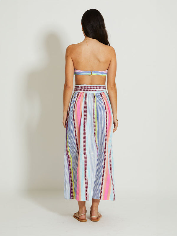 Back of a Woman Standing Wearing lemlem TOLA | Skirt featuring  intricate stripes in sun-washed hues and a Tibeb-inspired pattern in rich dark plum