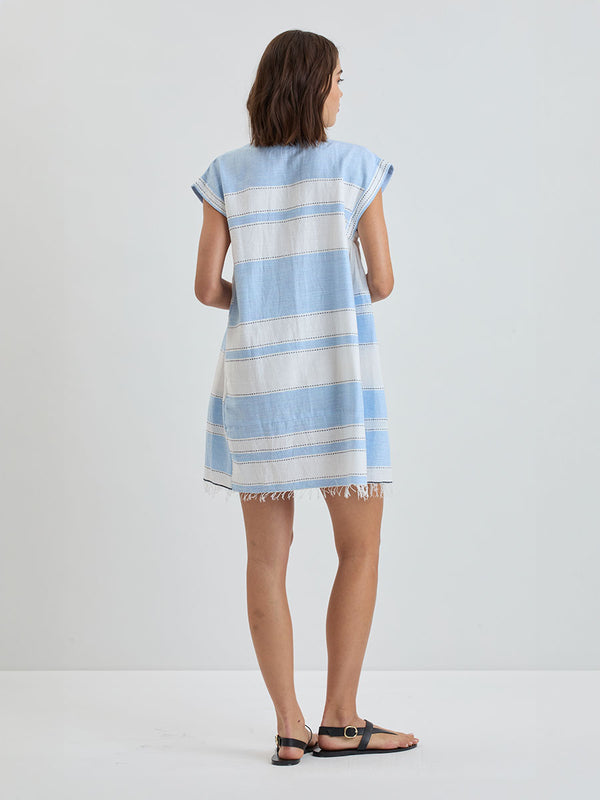 Back of a Woman Standing wearing lemlem ELINA Caftan featuring bold, crisp white stripes on a sky-blue background, accented with black detailing.