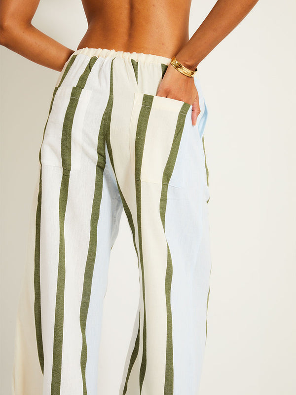 Close up on a back of a Woman Standing Wearing lemlem Desta Pants featuring a bold asymmetrical color-block pattern, where airy light blue effortlessly blends with soft sage and cream