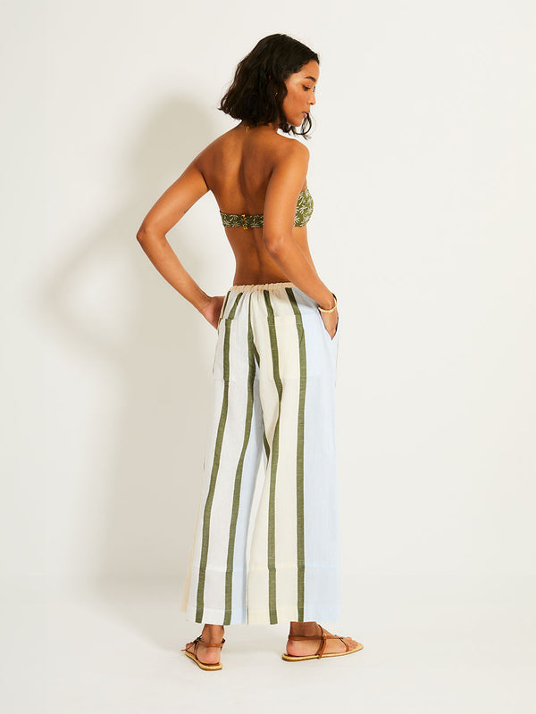 Back of a Woman Standing Wearing lemlem Desta Pants featuring a bold asymmetrical color-block pattern, where airy light blue effortlessly blends with soft sage and cream