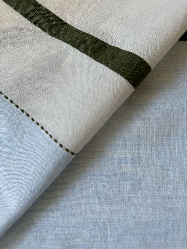 Close up on lemlem Entoto Sage Fabric featuring a bold asymmetrical color-block pattern, where airy light blue effortlessly blends with soft sage and cream