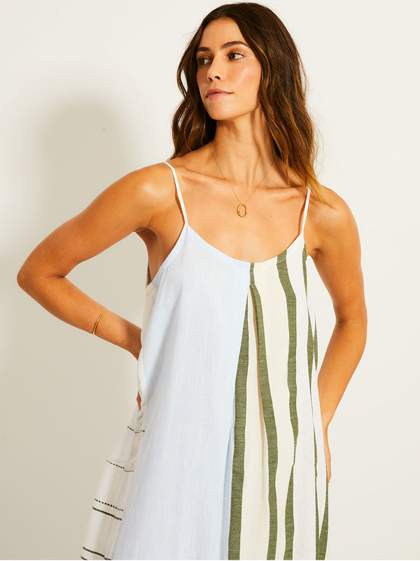 Close up on a Woman Standing Wearing lemlem NIA Dress featuring a bold asymmetrical color-block pattern, where airy light blue effortlessly blends with soft sage and cream