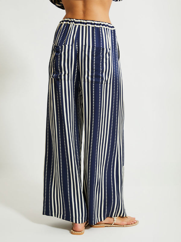 Back close up of a Woman Standing Wearing lemlem Desta Pants featuring a classic navy background with ivory stripes and dots 