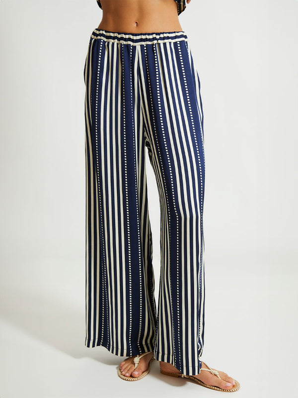 Front close up of a Woman Standing Wearing lemlem Desta Pants featuring a classic navy background with ivory stripes and dots 