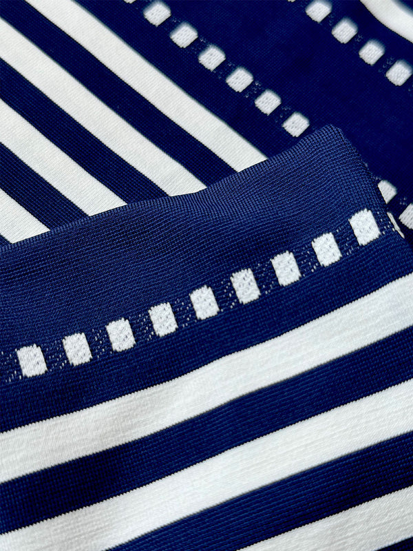 Close up on  lemlem Eshe Navy Farbric featuring a classic navy background with ivory stripes and dots