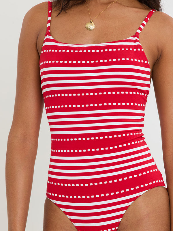Red and white striped swimsuit worn by a woman on a plain background