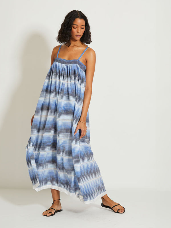 Woman Standing wearing lemlem EDA Slip dress featuring ombre pattern in navy, blue, pale blue and white colors