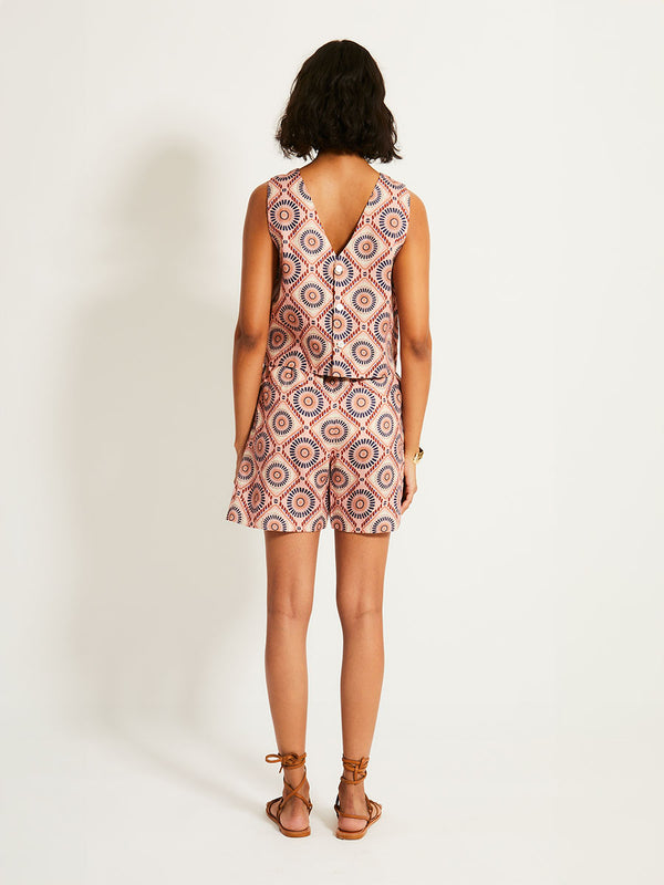 Back of a Woman Standing Wearing lemlem ADOWA | Shell Tank  featuring a Yani Tibeb-inspired pattern in peach, rust, and orchid hues, accented with a bold citrus yellow pop and matching shorts