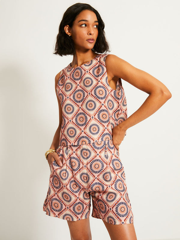 Woman Standing Wearing lemlem ADOWA | Shell Tank  featuring a Yani Tibeb-inspired pattern in peach, rust, and orchid hues, accented with a bold citrus yellow pop and matching shorts
