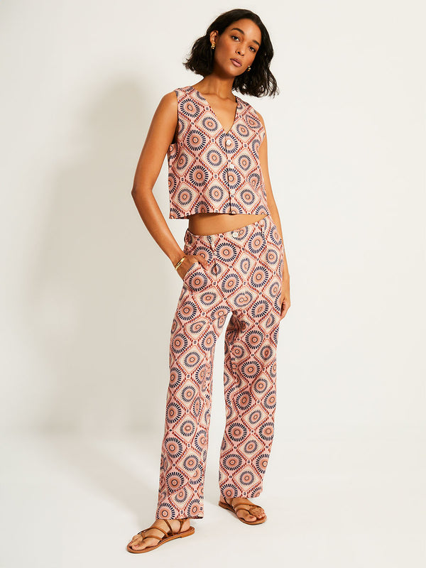 Woman Standing Wearing lemlem ADOWA | Shell Tank  featuring a Yani Tibeb-inspired pattern in peach, rust, and orchid hues, accented with a bold citrus yellow pop and matching pants
