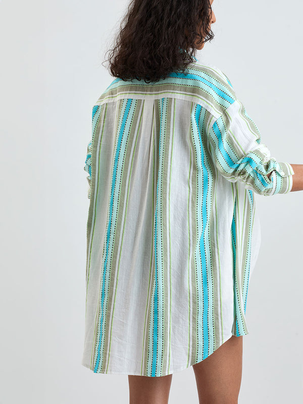 Back of a Woman wearing lemlem MARIAM Shirt featuring a chic stripe pattern in aqua blue and sage tones, delineated by dark olive dots and accented with a splash of neon yellow on a cream background