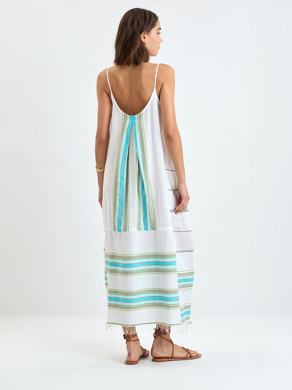 Back of a  Woman wearing lemlem NIA Slip Dress featuring a chic stripe pattern in aqua blue and sage tones, delineated by dark olive dots and accented with a splash of neon yellow on a cream background 