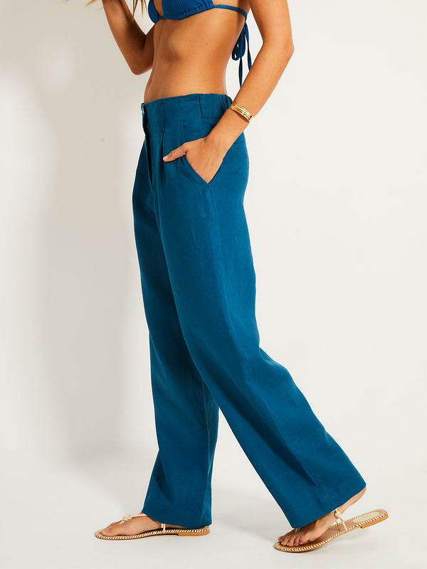 Close up on a Woman Standing Wearing lemlem DIARRA | Pants featuring a rich mid-blue green color and triangle bikini top in the same color
