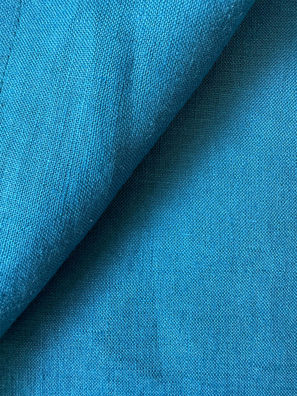 Close up on lemlem kianos teal fabric featuring a rich mid-blue green color