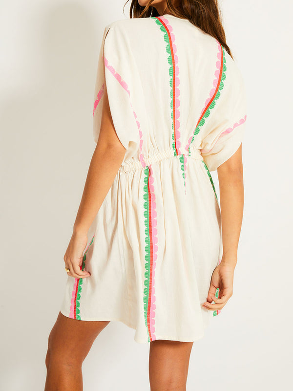 Back of a Woman Standing Wearing lemlem ALEM Plunge Dress featuring a playful, preppy scalloped Tibeb weave with vibrant green, soft pink, and fiery red accents.
