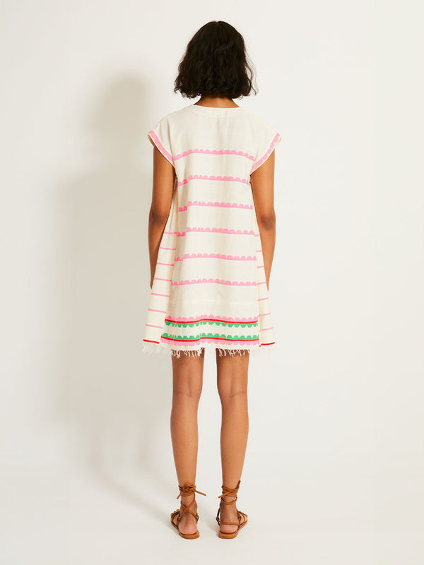 Back of a Woman Standing Wearing lemlem ELINA Caftan featuring a playful, preppy scalloped Tibeb weave with vibrant green, soft pink, and fiery red accents