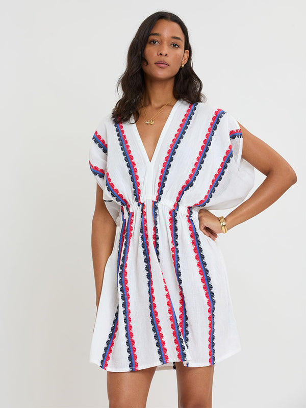 Woman Standing wearing lemlem handwoven ALEM Dress featuring a playful, preppy scalloped Tibeb weave with classic navy, red, and vibrant blue accents.