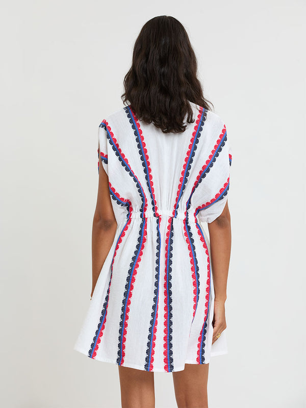 Woman Standing wearing lemlem handwoven ALEM Dress featuring a playful, preppy scalloped Tibeb weave with classic navy, red, and vibrant blue accents.